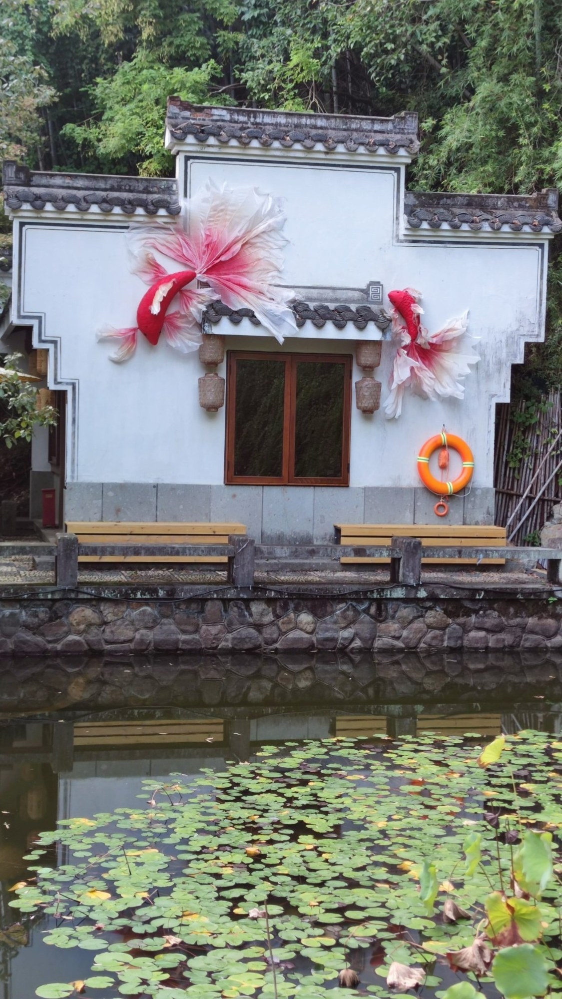 Haus am Wasser mit Lotosblättern und Wanddekoration