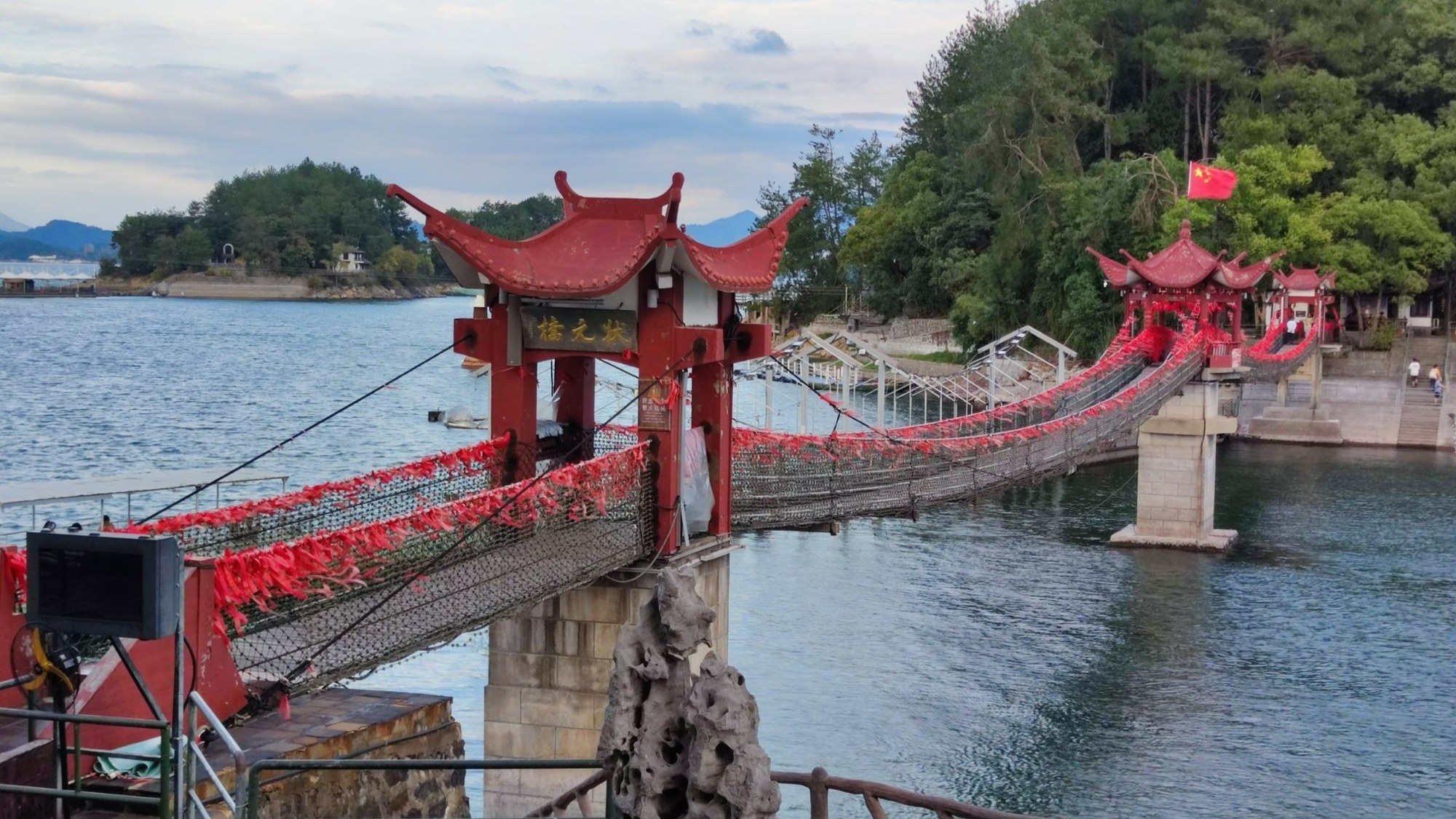 Qiandao Lake / 1000 Seen: rote Hängebrücke am Wasser