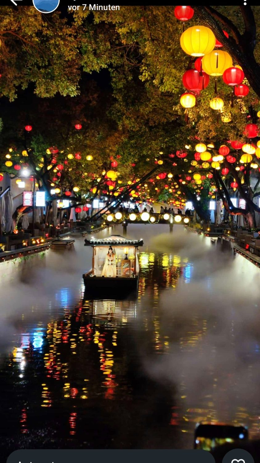 Huishan Ancient Town in Wuxi bei Nacht mit Kanal, Laternen und Boot