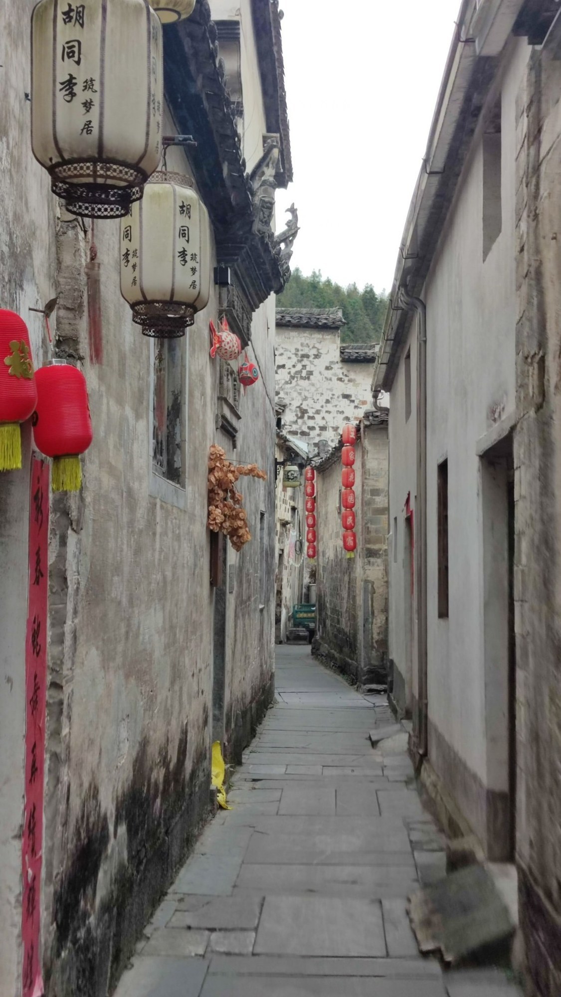 Schmale Gasse in Xidi mit Laternen und alten Häusern