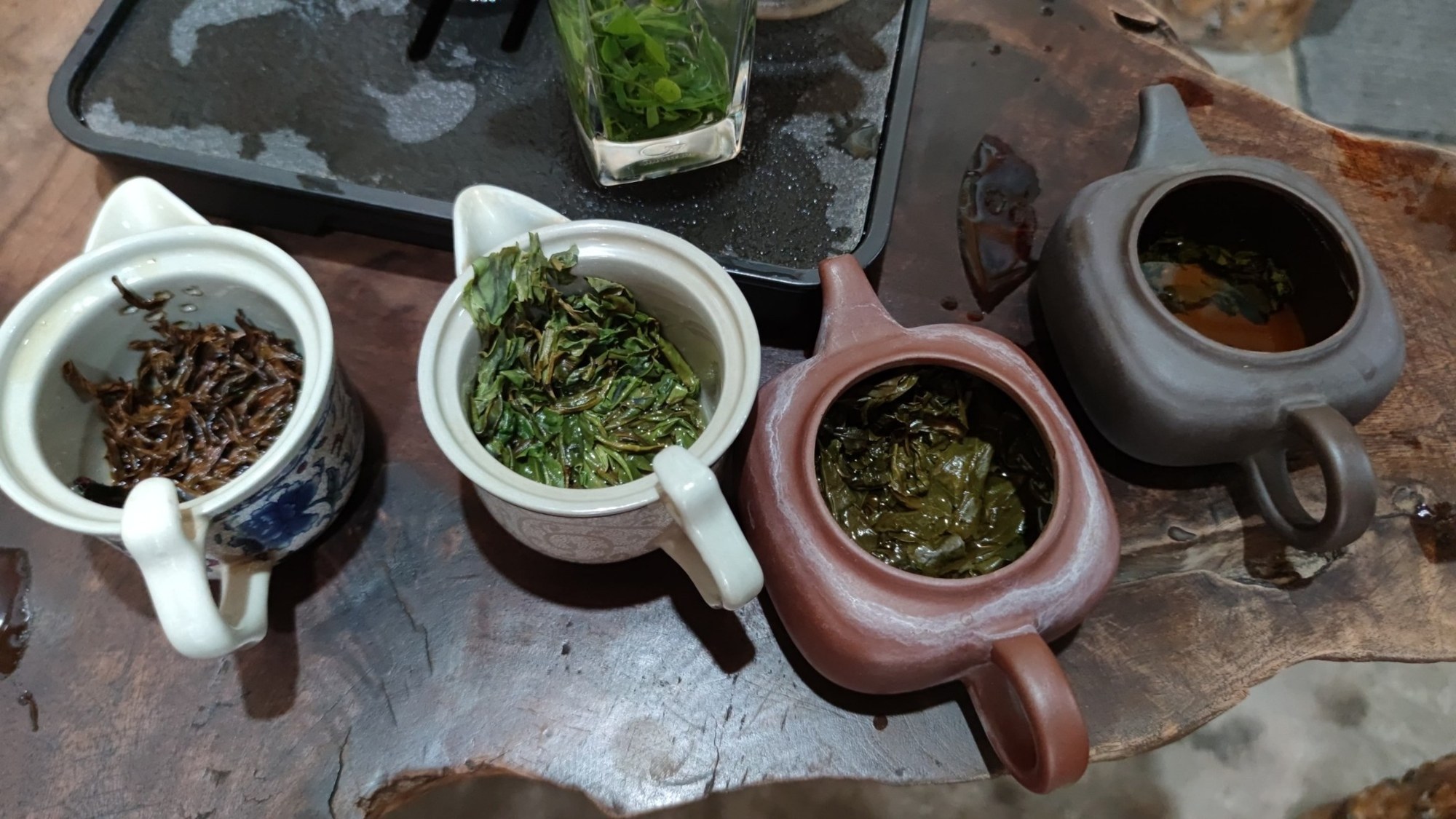 Teeprobe in Xidi mit kleinen Kannen und Teeblättern